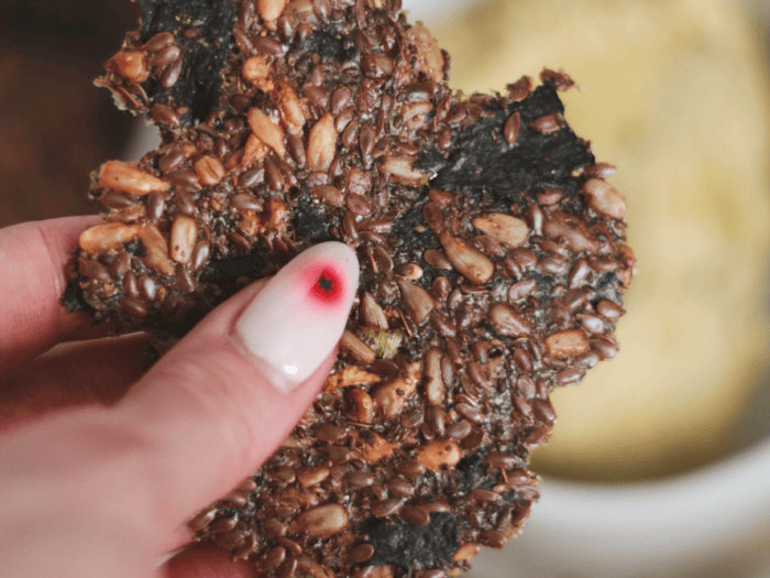 seedy seaweed cracker being held up to camera