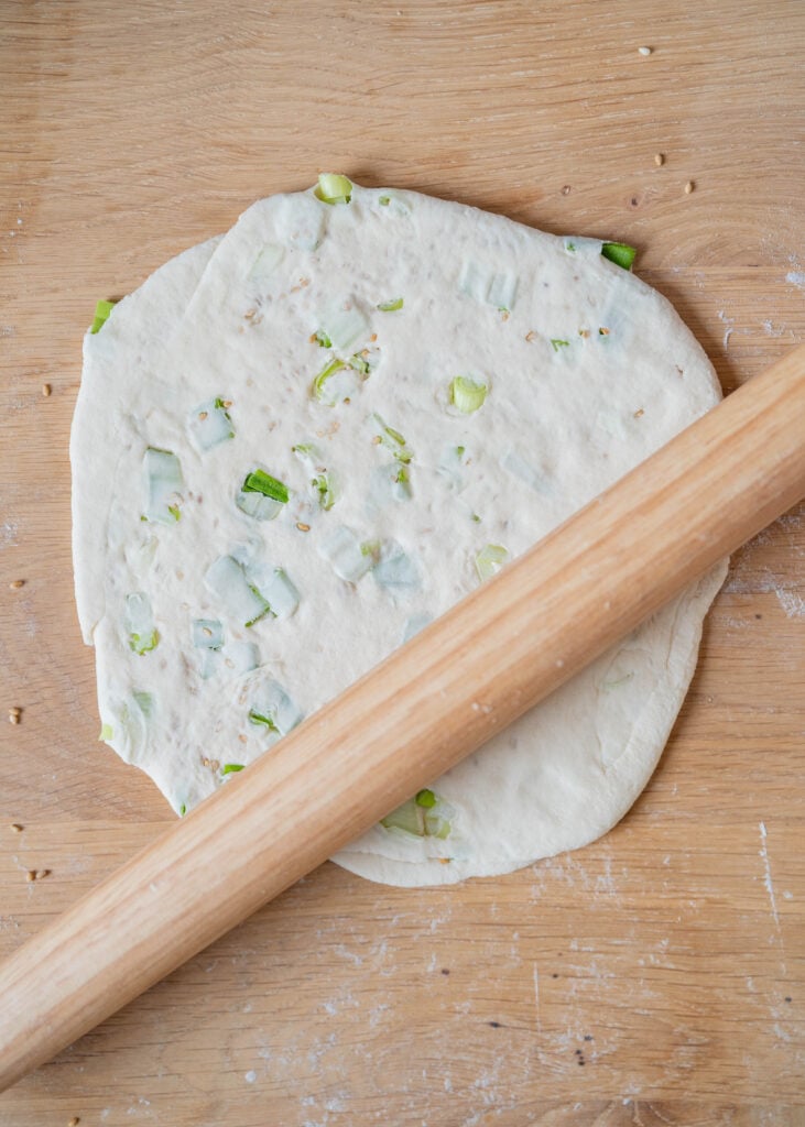 rolling out dough into pancake circle with rolling pin