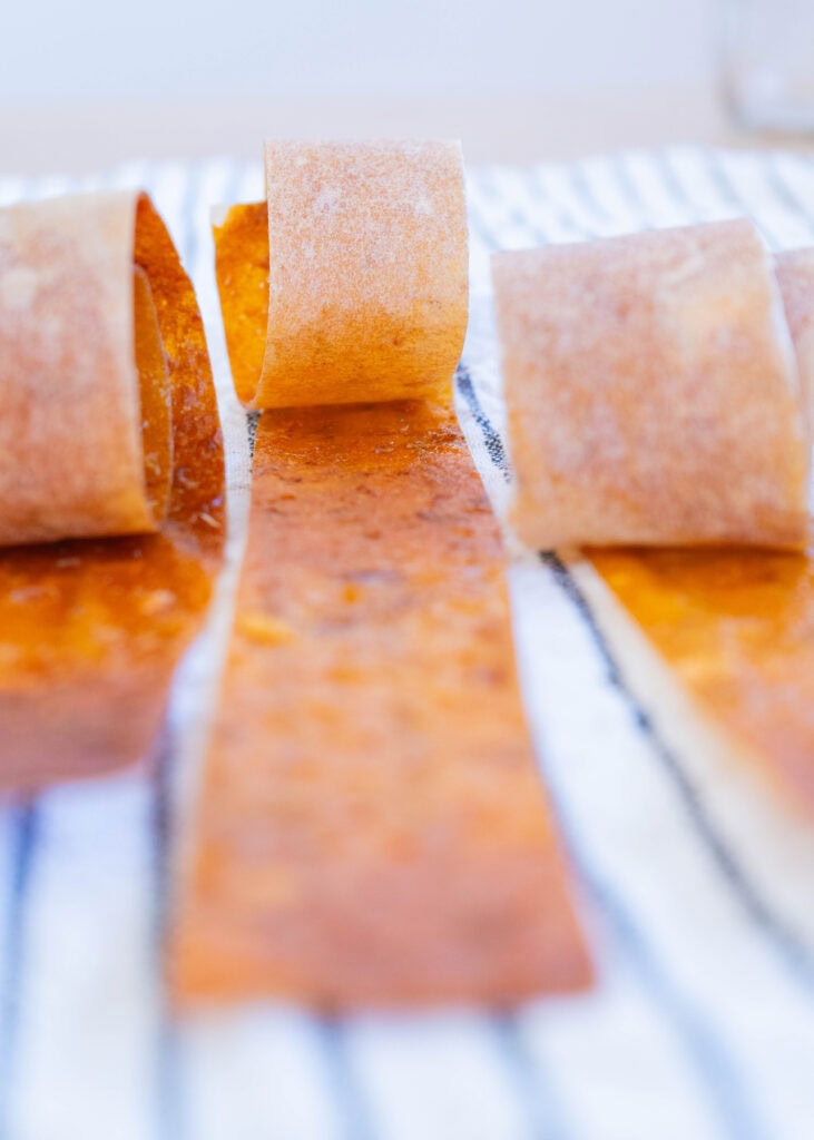 homemade baked fruit leather cut into strips and rolled