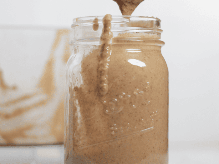 jar of tahini with a wooden spoon